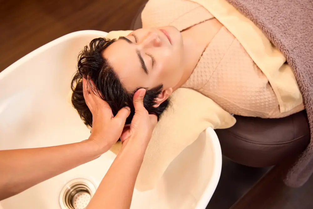 Male guest receiving a relaxing scalp massage from a therapist during a Head Spa treatment at Siesta Head Spa and Salon in Bangkok.