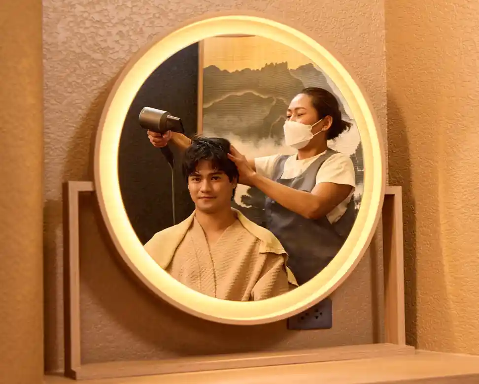 Therapist applying Helma Scalp Essence followed by blow-dry and light styling during the Aroma Oil Tranquility Program.