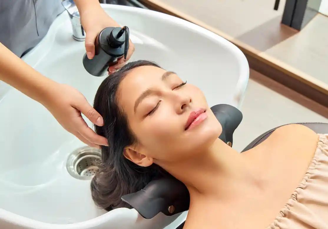 Therapist performing Scalp & Hair Booster Treatment and Thai signature head massage during the Signature Scalp program.